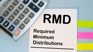 RMD paper in an article about Retirees in Greenville, Simpsonville, Clemson, and Anderson County, SC, utilizing Qualified Charitable Distributions (QCDs) to maximize tax benefits while fulfilling Required Minimum Distributions (RMDs) and supporting charities.