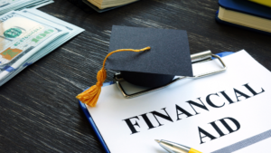  A graduation cap resting on financial aid documents, symbolizing the importance of financial planning and FAFSA guidance in Greenville, SC. Highlighting how financial advisors in Greenville can help students maximize aid and plan for a debt-free future.