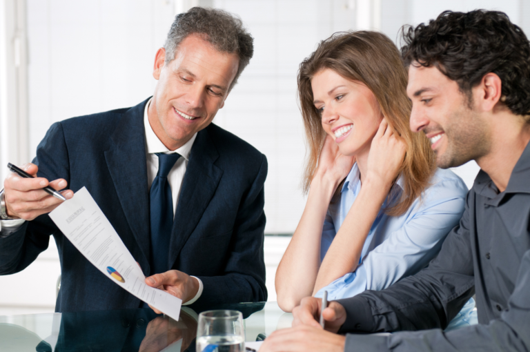 A couple sits at a table in Greenville, SC, reviewing investment documents and discussing financial strategies for 2025 with a focus on portfolio diversification and long-term planning with a financial advisor.