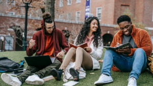 A group of college students laughing and socializing on campus, highlighting the college experience beyond tuition.