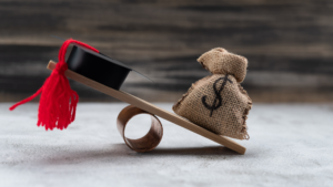 A balanced scale with a graduation cap on one side and money on the other, representing college costs and financial planning.