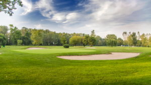 Golf course landscape with green fairway and blue sky